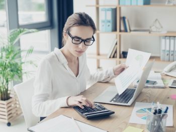 Successful Business Woman Economist In Formal Wear, Sitting At Her Work Place In A Light Modern Design Office, Making Report, In Front Of Laptop, So Stylish, Concentrated And Thoughtful